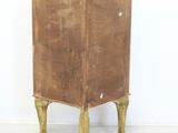 an old wooden cabinet with two legs and a door