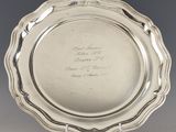 un plat ancien en argent, orné d'une inscription, posé sur un socle