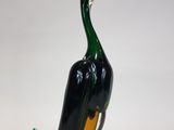 a glass duck that is sitting on a white surface
