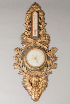 a gold clock hanging on the wall in a room
