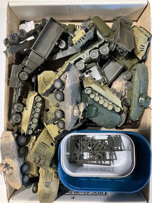une boîte remplie de véhicules militaires miniatures et d'autres jouets