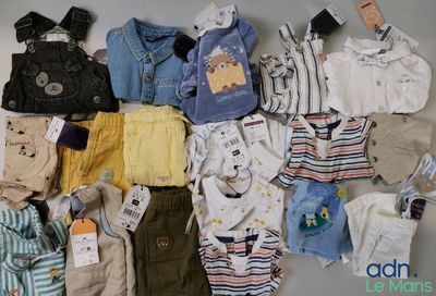 beaucoup de vêtements de bébé étalés sur une table