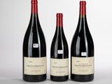 trois bouteilles de vin rouge sont alignées sur une table