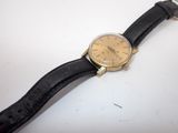 une montre posée sur un bracelet en cuir noir