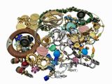 a pile of assorted jewelry on a white surface