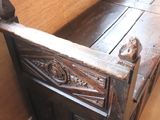 a wooden bench in the corner of a room next to a window
