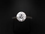 une bague en diamant posée sur une surface noire, avec un fond noir