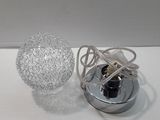 a light that is sitting on a table next to a ball