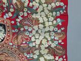 a close up of a red scarf with flowers and paisleys