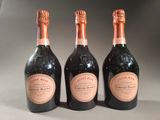 three bottles of champagne sitting next to each other on a table