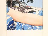 a polaroid picture of a person laying in a car