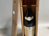 une bouteille de vin dans un coffret en bois sur une table