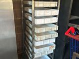 several trays of food are stacked on a cart in a kitchen