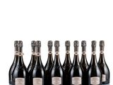 six bottles of champagne lined up in a row on a white surface
