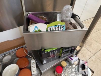 un évier en métal dans lequel se trouvent de nombreux objets