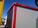 an image of a red and gray portable toilet in a parking lot