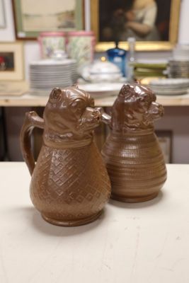 two brown vases sitting on a table in front of a picture