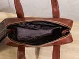 a brown purse sitting on top of a wooden table