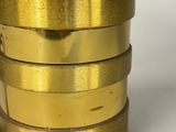 three gold colored cups are stacked next to each other on a white surface