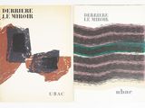 two books on a white surface with a black and green cover