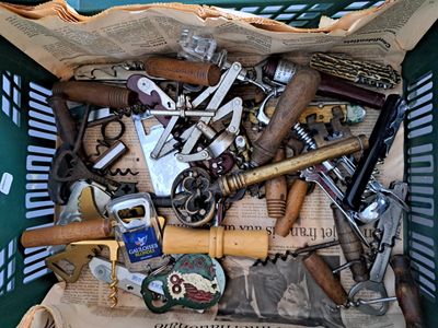 a green basket filled with assorted tools on top of a table