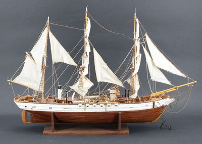 une maquette en bois d'un voilier aux voiles blanches