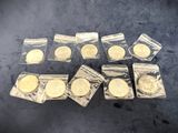 several gold coins are in plastic bags on a table