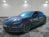 une Porsche Panamera noire garée sur un sol en carrelage à damier
