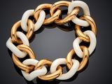 a close up of a gold and white bracelet on a black surface