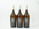trois bouteilles de vin posées sur une table blanche
