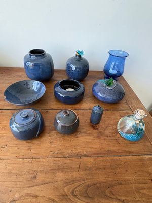 une table en bois sur laquelle sont disposés des vases et des bols bleus