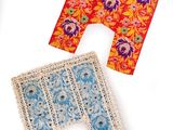 three pieces of cloth and a pair of scissors on a white surface