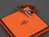 une boîte orange avec un cadenas argenté posée sur une surface noire