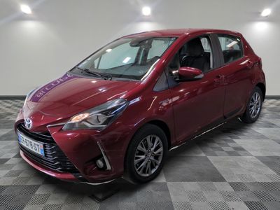 une Toyota Yaris rouge garée sur un sol à damier