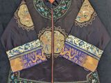 un gros plan sur une veste noire ornée d'un motif coloré