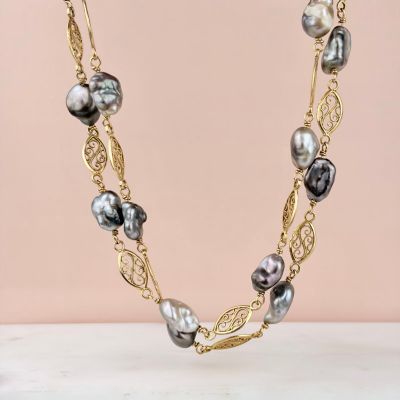 a black and white pearl necklace on a gold chain