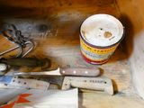 a bucket of paint next to a knife and a pair of scissors