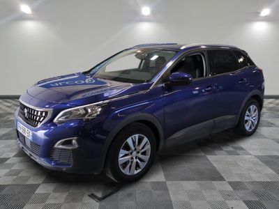 une voiture bleue est garée dans une pièce au sol à carreaux