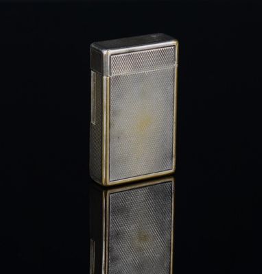 un vieux briquet en argent posé sur une surface noire