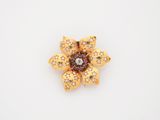 une image représentant une broche en forme de fleur en or sertie de diamants, sur fond blanc