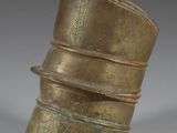 an old brass vase with a curved top sitting on top of a table