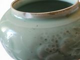 a green vase that is sitting on a table