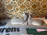 two rabbits that are sitting on a pillow on the bed