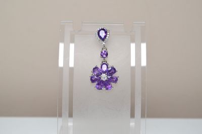 amethorate and diamond earrings in a clear display case