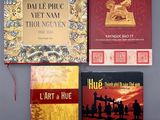 trois livres sont posés sur une surface grise, avec un ruban rouge