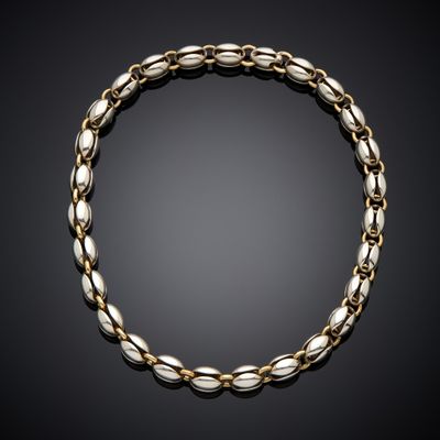 a gold and silver bracelet on a black background