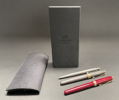 silver and red pen and pencil set in a gift box on a gray surface