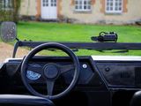 a steering wheel and dashboard of a car with a view of a house in the background