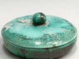 a green box with a ball on top of it