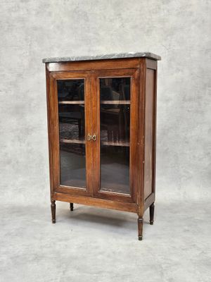 une vieille armoire en bois avec des portes vitrées et un plan de travail en marbre